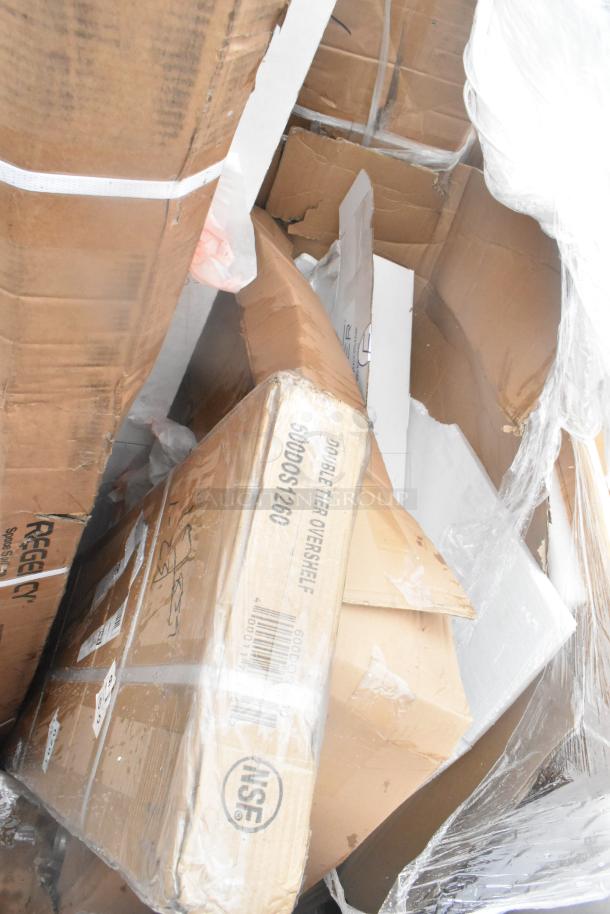 Cardboard boxes containing six new scratch and dent items, including a double-tier overshelf, visible labels.