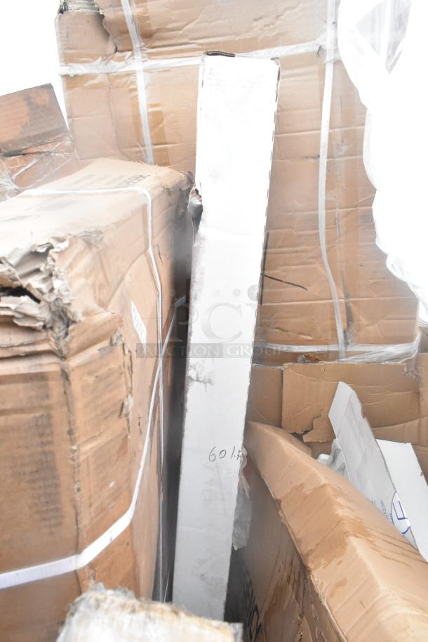 Stack of six brand new items in damaged packaging, including shelves. Some boxes marked "60 lb." Visible wear on boxes.