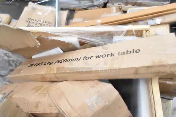 Stacked boxes labeled "201SS Leg (820mm) for work table," indicating contents for shelving and table items, brand new but with visible dents.