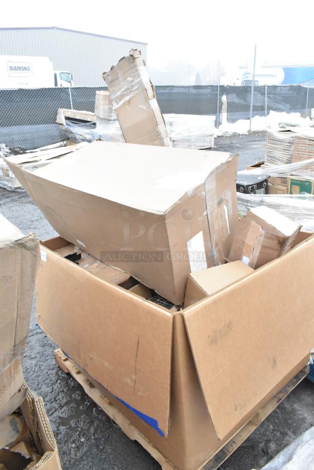Damaged cardboard boxes on a pallet, containing assorted scratch and dent items like gloves, cart, and ingredient bin.