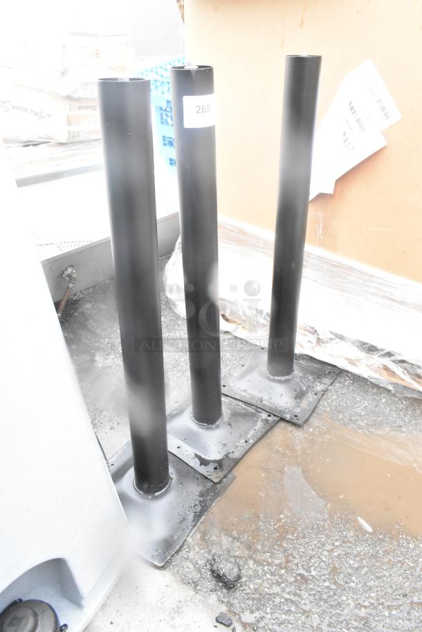 Three black table base columns with square mounting plates, brand new with minor scratches. Label shows number 265.