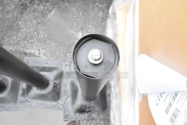 Three new table base columns, black metal, with visible bolt and slight dents. Comes with 3 times bid value offer.