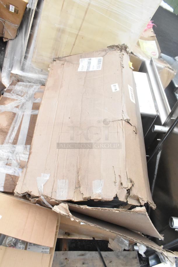 Cardboard boxes containing 6 brand new scratch and dent items, including a floor mat and wall shelf, partially open.