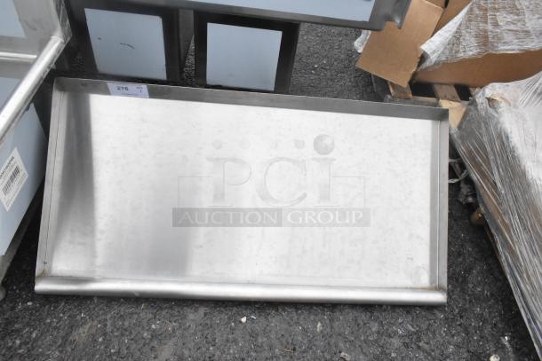 Brand new scratch and dent wall shelf, stainless steel, slight imperfections visible, item tag reads "Qty 1 - 276".
