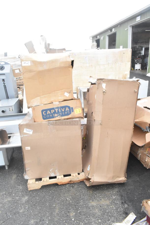 Sealed cardboard boxes on a pallet with "Captiva Containers" label, containing brand new scratch and dent sinks.