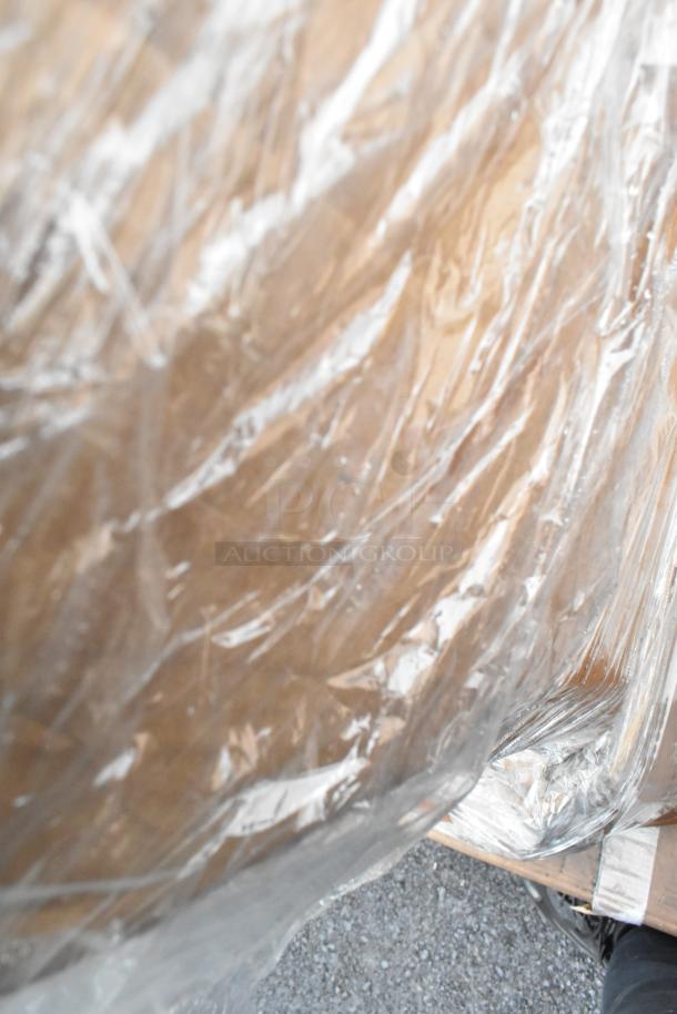 Pallet wrapped in plastic containing six items, including pie pans and a work table, in scratch and dent condition.