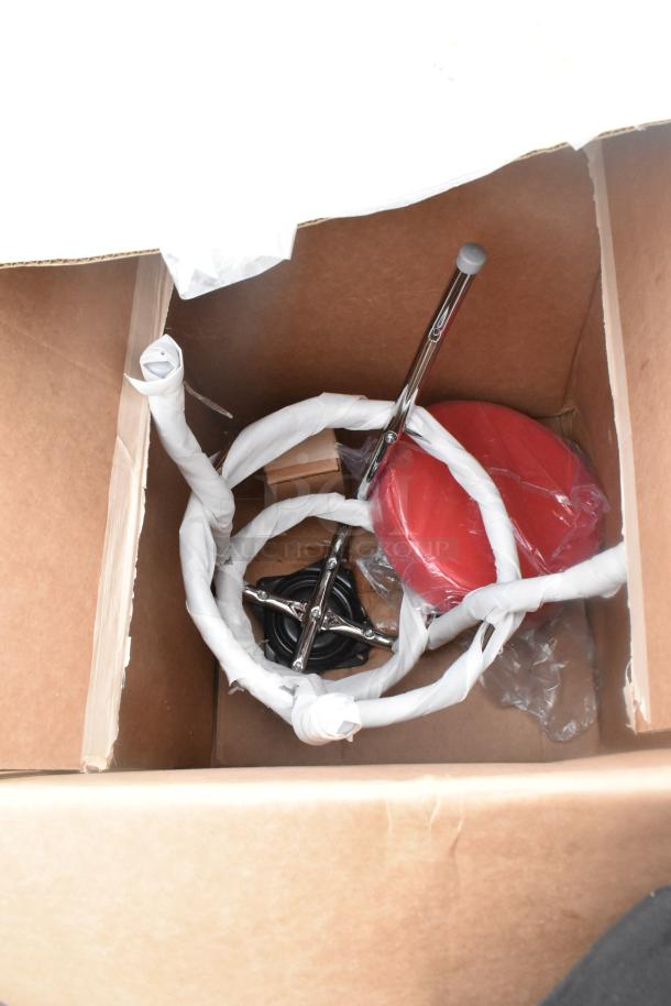 Box containing new items with some scratches and dents; visible are a red pie pan and metal components, with packaging material.