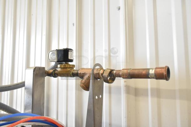 Industrial plumbing pipe setup with valve adjacent to the Noble CONSERVER XL dishwasher.