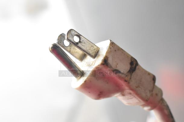 Close-up of a plug from a Magic Pop DMP-1 rice cake machine, showing signs of wear and use.