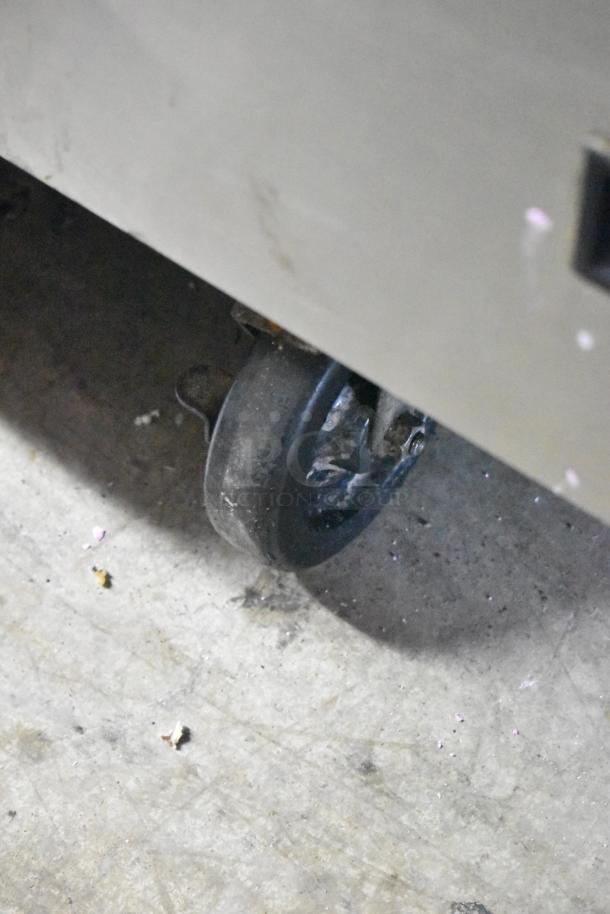 Delfield 4 Drawer Chef Base on commercial casters, 115 volts, 1 phase, showing a durable caster for mobility.