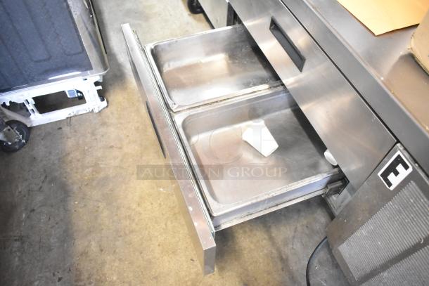 Delfield commercial 4-drawer chef base on casters, stainless steel, 115 volts, 1 phase, with open drawer showing two pans.