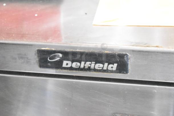 Delfield commercial 4-drawer chef base on casters, stainless steel, 115V, 1 phase, visible brand label.