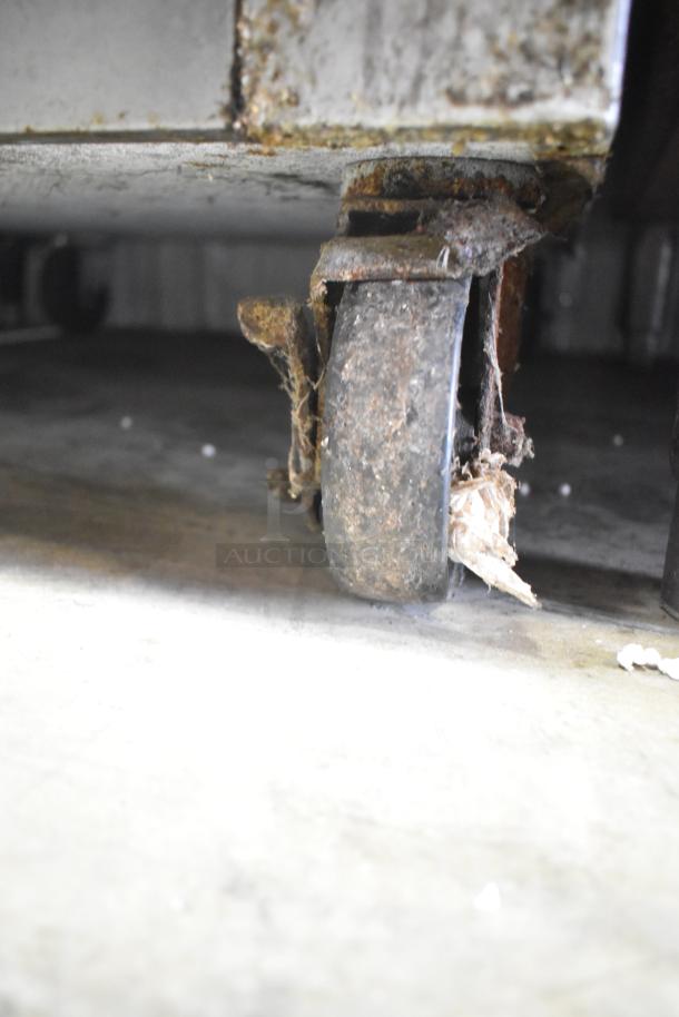 Continental 1R-HD cooler caster, showing rust and wear. Item is a commercial half-size reach-in cooler on casters.