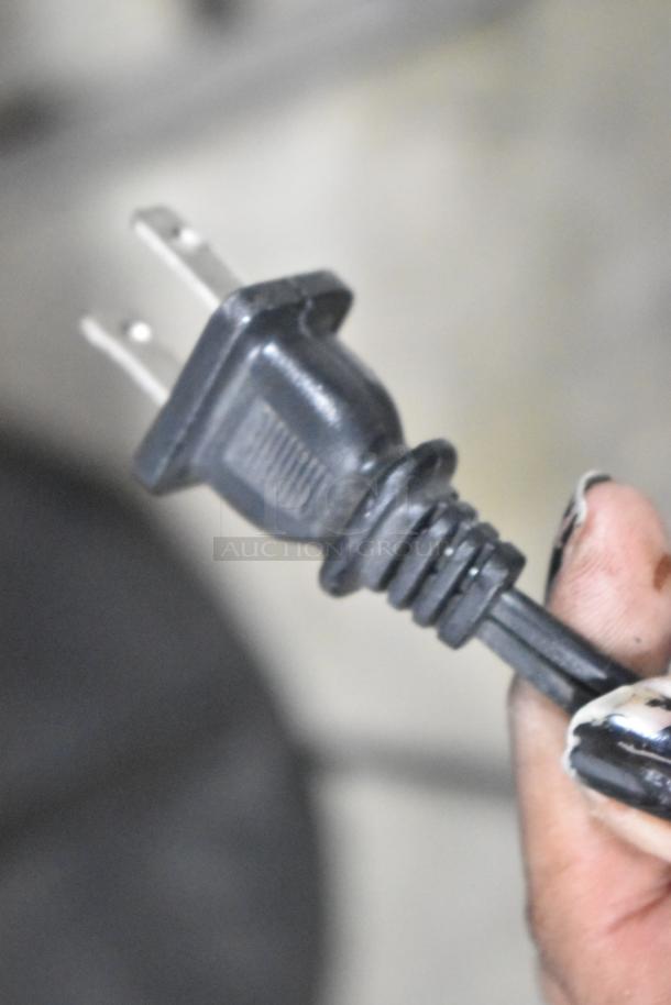 Power plug for light fixture with 3 under shelves, showing a standard two-prong design.