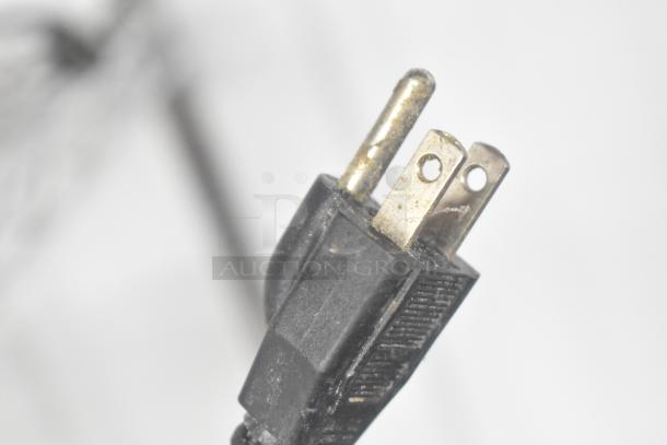Close-up of a power plug for a Globe IR1800 induction range, showing three metal prongs.