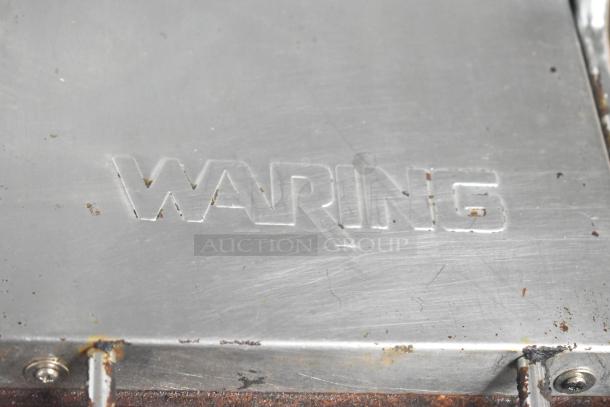 Waring WPG300 Double Panini Press, visible brand logo, used condition with some rust, operates on 240 volts, 1 phase.