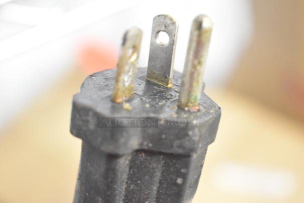 Close-up of a plug for the Waring WPG300 Double Panini Press, showing a three-prong connector with slight wear.