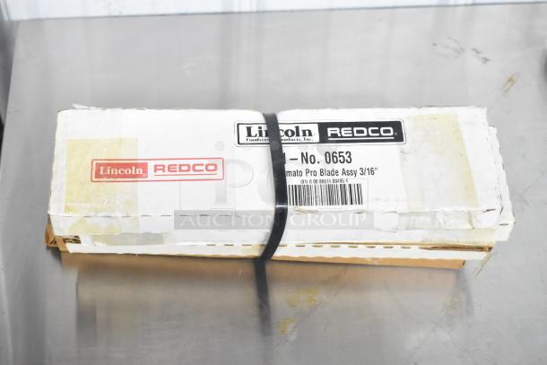 Box of Lincoln Redco 0653 Tomato Blade Assy, sealed, with visible labels. Includes 8 various items.