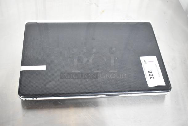Gateway KAYF0 laptop, closed, black finish with textured design. Auction tag displaying “306”. Good condition.