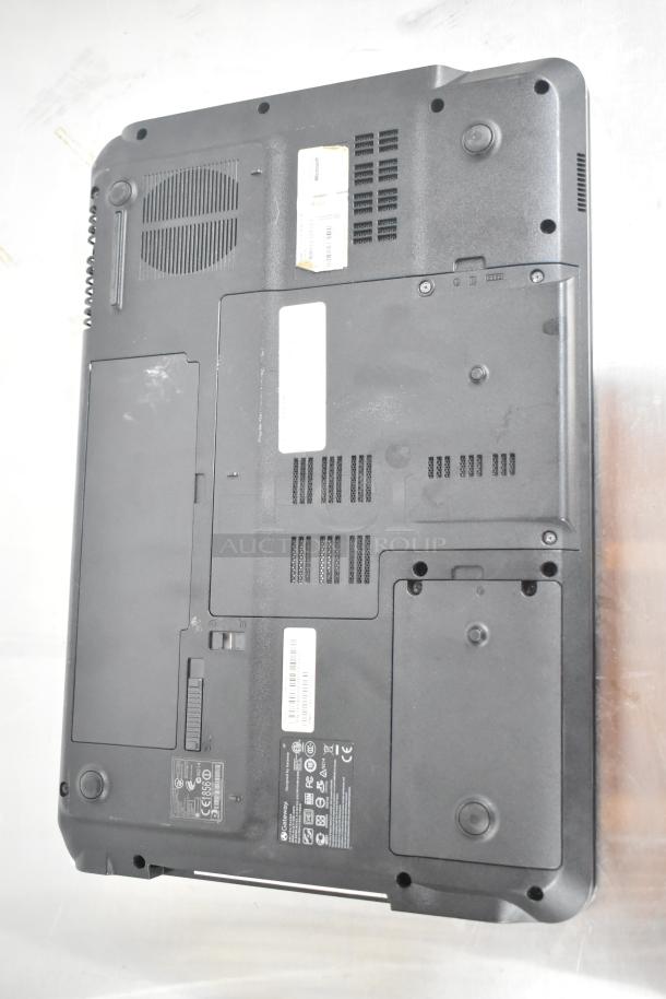 Gateway KAYF0 laptop bottom view, showing vents, labels with specifications, and model markings. Minor wear visible.