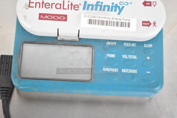 EnteraLite Infinity Enteral Pump by Moog, featuring a digital display and control buttons, showing signs of use.