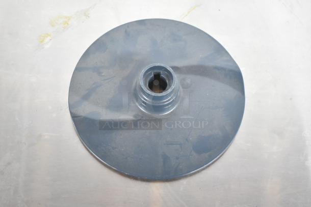 Circular attachment with a central fitting, likely a food processor blade. Appears slightly worn; use for grating tasks.