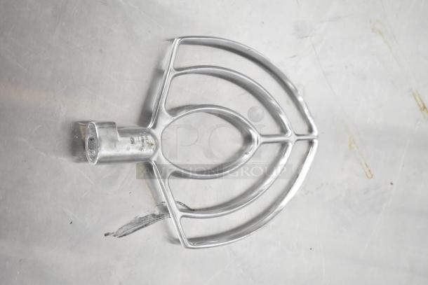 Stainless steel paddle attachment, slightly worn, compatible with stand mixers. Visible markings indicate standard size.