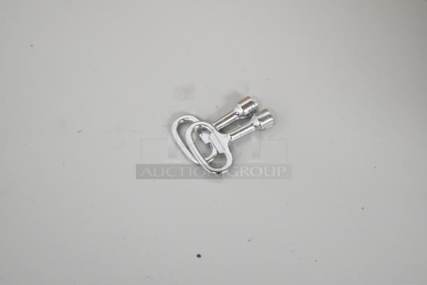 A small, metallic key lays on a white surface.