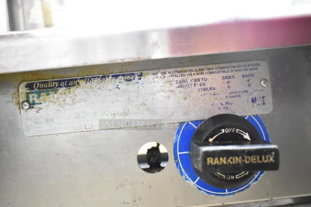 Rankin-Delux 2 Burner Range, propane gas, commercial countertop, visible wear, labeled with model details and safety instructions.