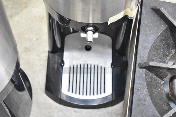 3 Fetco Luxus countertop beverage holder dispenser in metal and black. Features a spout and white grate. Good condition.