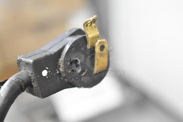 Close-up of a damaged power plug with visible wear and broken prong, requiring replacement.