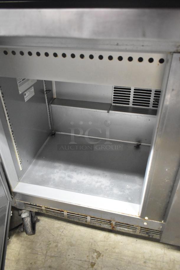 Beverage Air SPE48-18M-HMP commercial prep table; interior view, shows shelving space; mounted on commercial casters.