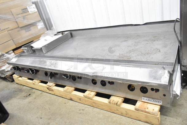 Garland commercial countertop gas-powered flat top griddle. Stainless steel, signs of use, controls front-facing, Garland label.