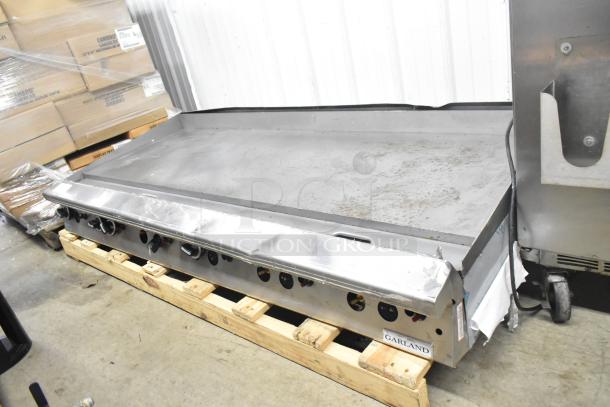 Garland commercial countertop gas griddle, flat top, signs of use, stainless steel, control knobs, "Garland" label visible.