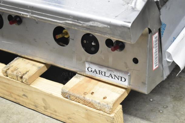 Garland Commercial Countertop Gas Flat Top Griddle, metallic finish, resting on wooden pallet. Garland label visible.