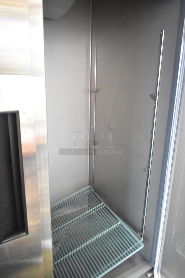 Brand new KoolMore RIR-2D-SS commercial cooler interior, showing shelves and adjustable rack slots, on commercial casters.