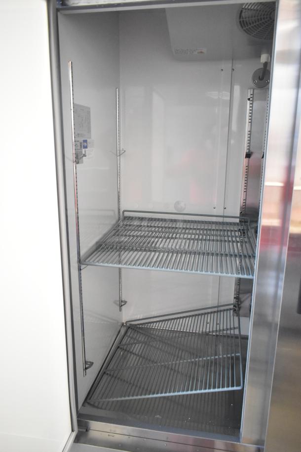 Brand new Avantco 178A49RHC commercial 2-door reach-in cooler, 115V, 1 phase, with shelving; slight scratches/dents visible.