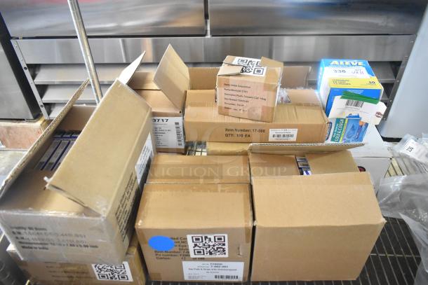 Boxes of brand new scratch and dent items, including tweezers, bandages, medicine, and eye pads, with visible barcodes and labels.