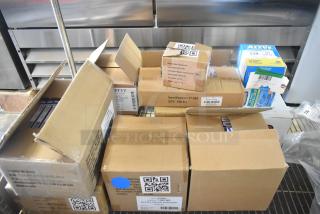 Boxes of brand new scratch and dent items, including tweezers, bandages, medicine, and eye pads, with visible barcodes and labels.