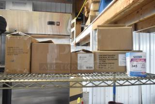 Six brand new "scratch and dent" boxes of medical supplies on a shelf, including PhysiciansCare and First Aid Only products with visible labels.