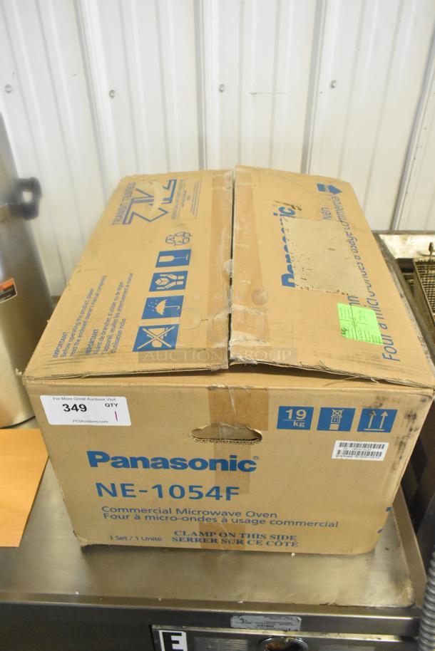 Original box of Panasonic NE-1054F commercial microwave, shows some wear. Box labeled with model and commercial use details.