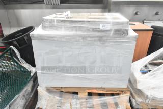 Plastic-wrapped table and wire shelves, brand new, scratch and dent condition, on a wooden pallet, with visible auction label.