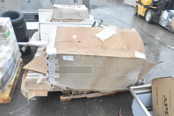 Four brand new scratch and dent items, including an ice bin and shelves, in original packaging with visible box damage.