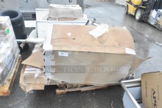 Four brand new scratch and dent items, including an ice bin and shelves, in original packaging with visible box damage.