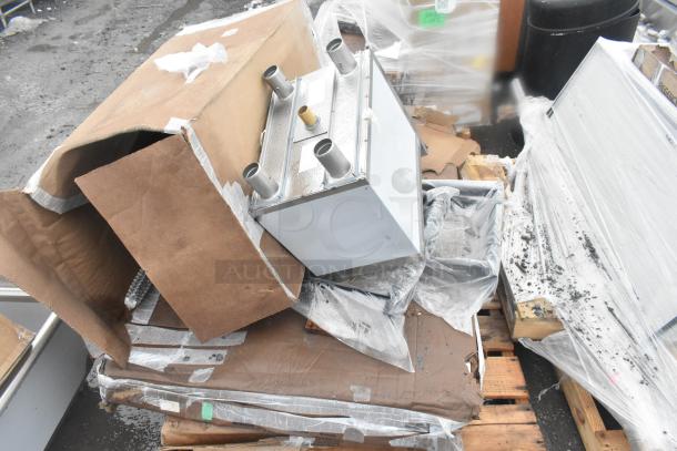 Four brand new scratch and dent items, including an ice bin and shelves, shown on pallets with packaging.