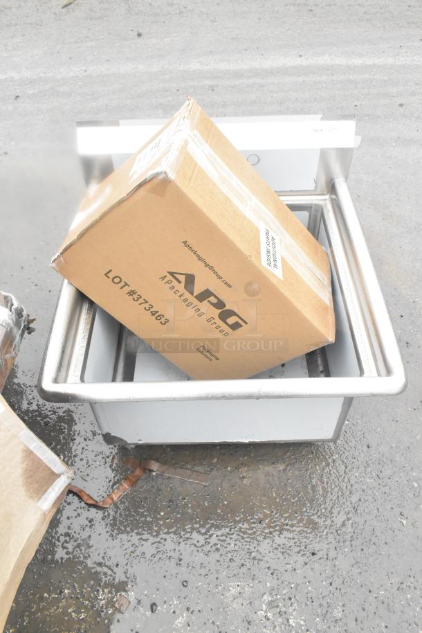 Cardboard box labeled "APG" Lot #373463 on a metal sink; part of a scratch and dent auction lot.