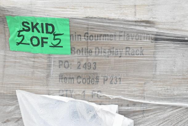 Skid labeled "2 of 5" containing scratch and dent items. Includes equipment stand, shelf kit, and work table. Wrapped in plastic.