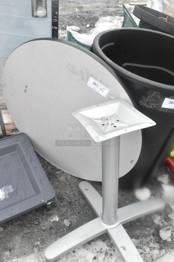 Round gray tabletop and table base, slightly worn, with visible label "362". Suitable for indoor or outdoor use.