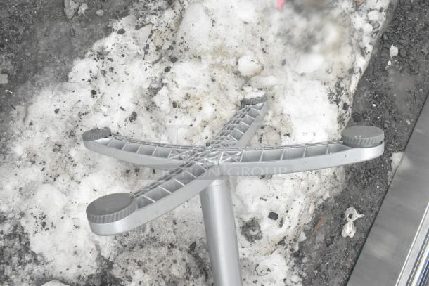 Gray table base with cross-shaped design, in good condition, shown outdoors on snow and gravel.
