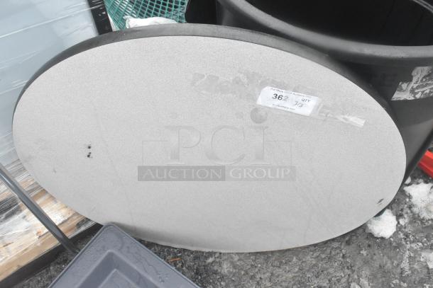 Round gray tabletop with visible wear, includes label "362" indicating quantity, set on gray table base.